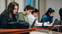 High school students using laptops as they use AI to support PBL