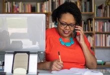 Woman talking on her phone at her desk