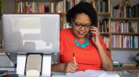 Woman talking on her phone at her desk