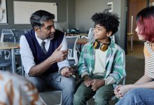 Teacher talking to small group of students, supporting their mental health needs