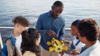 Adult showing robot to kids