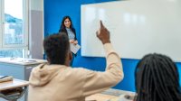 High school student raising hand during class to answer a question
