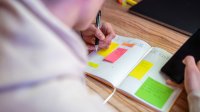Teenager recording assignments in a planner