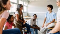 High school teacher chatting with small group of students