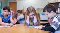 Elementary students reading in pairs