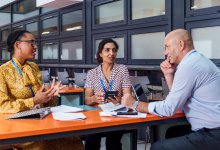 A photo of small group of teachers and administration in discussion