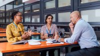 A photo of small group of teachers and administration in discussion