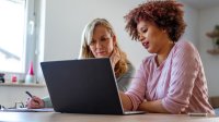 Two coworkers working on a laptop