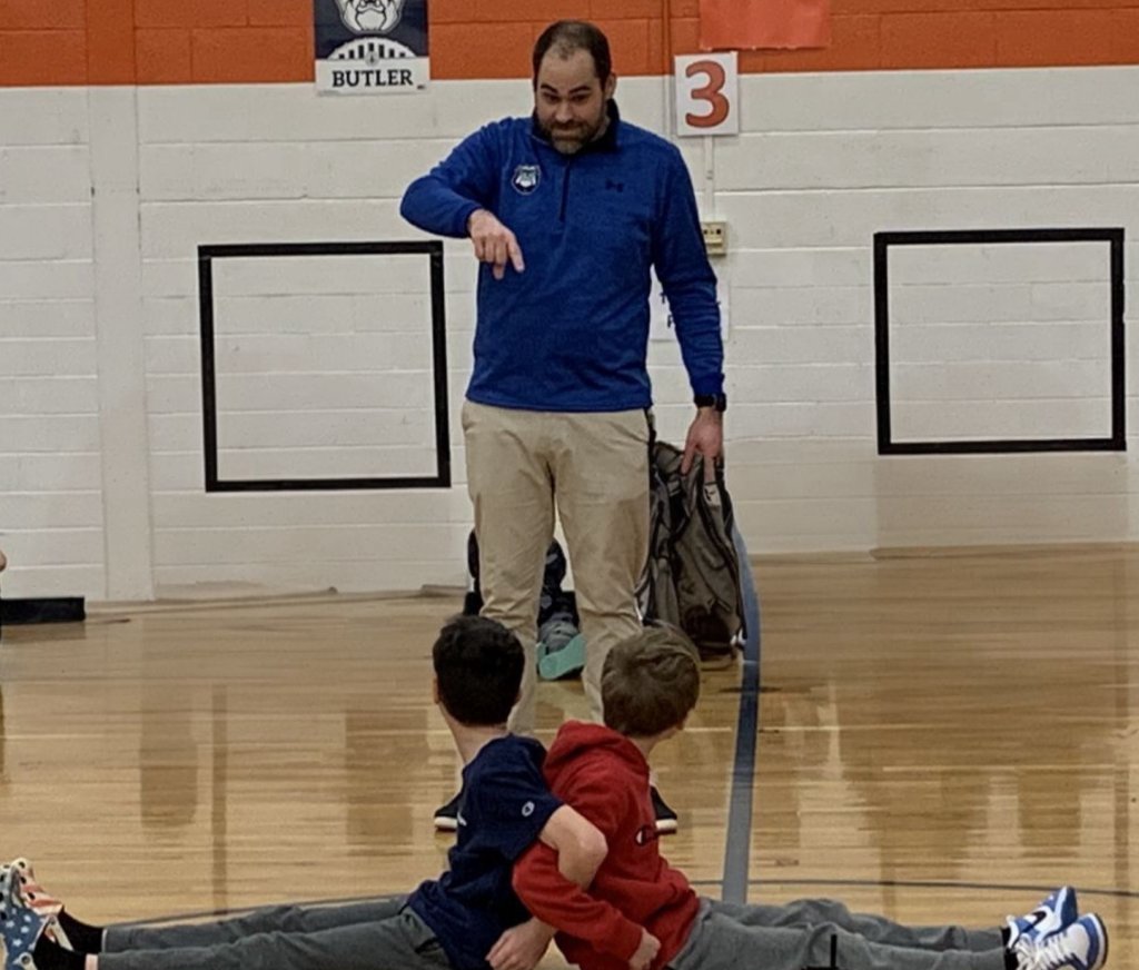 A photo of two students being led through an activity by a teacher