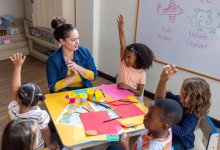 Elementary teacher works with a small group of students completing a project-based learning assignment