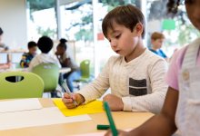 Prek student practicing writing skills by tracing letters