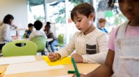 Prek student practicing writing skills by tracing letters