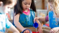 A photo of preschool students interacting with a water table