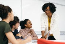 High school teacher talking to small group of students