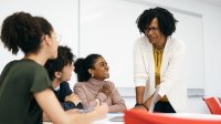 High school teacher talking to small group of students