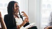 A photo of a principal engaged in a mediation with two implied teachers whose faces are out of the boundaries of the image.