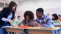 High school teacher helping two students