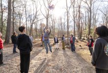 students at the Greene School passing a ball in the woods