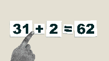 child's hand rotating a plus sign into a multiplication symbol to correct a math problem