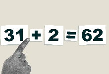 child's hand rotating a plus sign into a multiplication symbol to correct a math problem