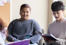Student reading a book in a small group discussion