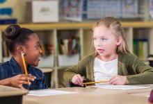 Two elementary students talking in class