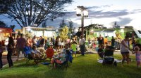 A photo of a community engaging with a row of food trucks