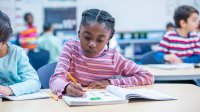 Elementary student using math workbook