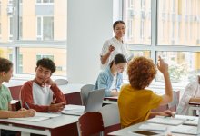 Teacher calling on student with raised hand