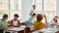 Teacher calling on student with raised hand
