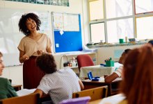 Young elementary teacher smiling at class