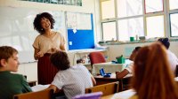 Young elementary teacher smiling at class