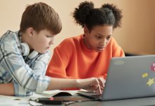 Two students working on a laptop together