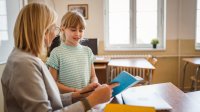 Elementary teacher and student talking