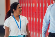 A photo of two administrators talking and walking in a school hallway.
