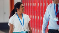 A photo of two administrators talking and walking in a school hallway.