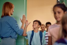 Teacher welcoming student with a high five