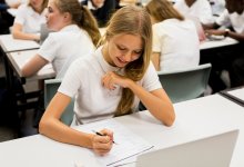 A photo of a middle school student having an "aha" moment while completing schoolwork at her desk.