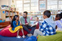 Teacher reading to students while sitting on beanbag chairs