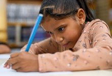 A photo of a first grade student diligently working on a writing assignment.