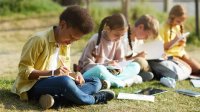 Elementary students writing outside