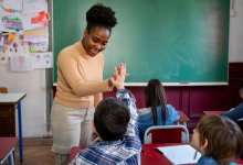 Elementary teacher giving student a high-five