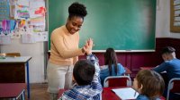 Elementary teacher giving student a high-five