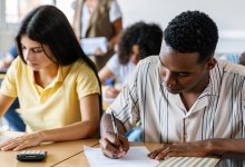 A photo of a classroom full of high school students individually working on an assessment.