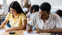 A photo of a classroom full of high school students individually working on an assessment.