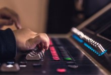A photo of an elementary student's hand touching a sound mixer.