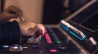 A photo of an elementary student's hand touching a sound mixer.