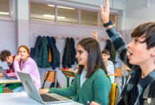 Engaged middle school classroom with student raising his hand