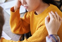 person comforting another person, representing the idea of coping with the death of a student