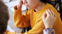 person comforting another person, representing the idea of coping with the death of a student